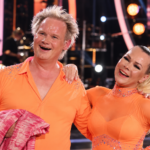 Valokuvassa Jani Halme ja Claudia Ketonen poseeraavat yhdessä tanssiesityksen lavalla oransseissa esiintymisasuissa.