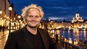Jani Halme hymyilee Helsingin iltavalaistulla rantakadulla kaupungin valojen loistaessa taustalla.