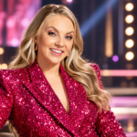 Veronica Verho poseeraa hymyillen näyttävässä pinkissä paljettiasussa värikkäässä tv-studiossa.